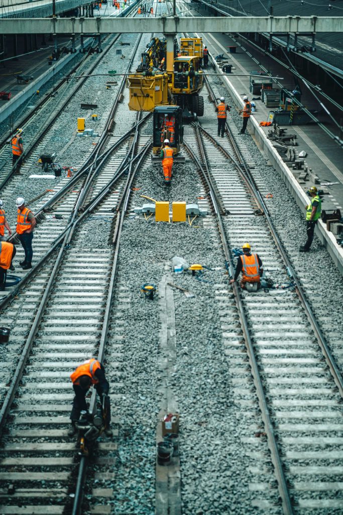 a group of men standing on top of train tracks