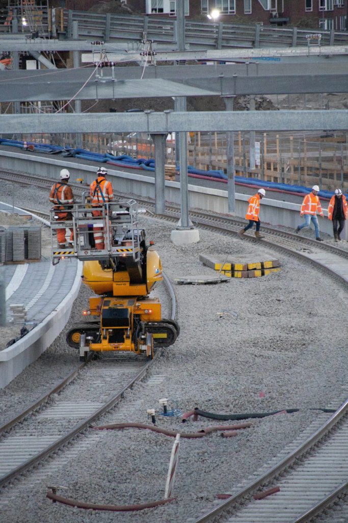 a group of men standing on top of a train track